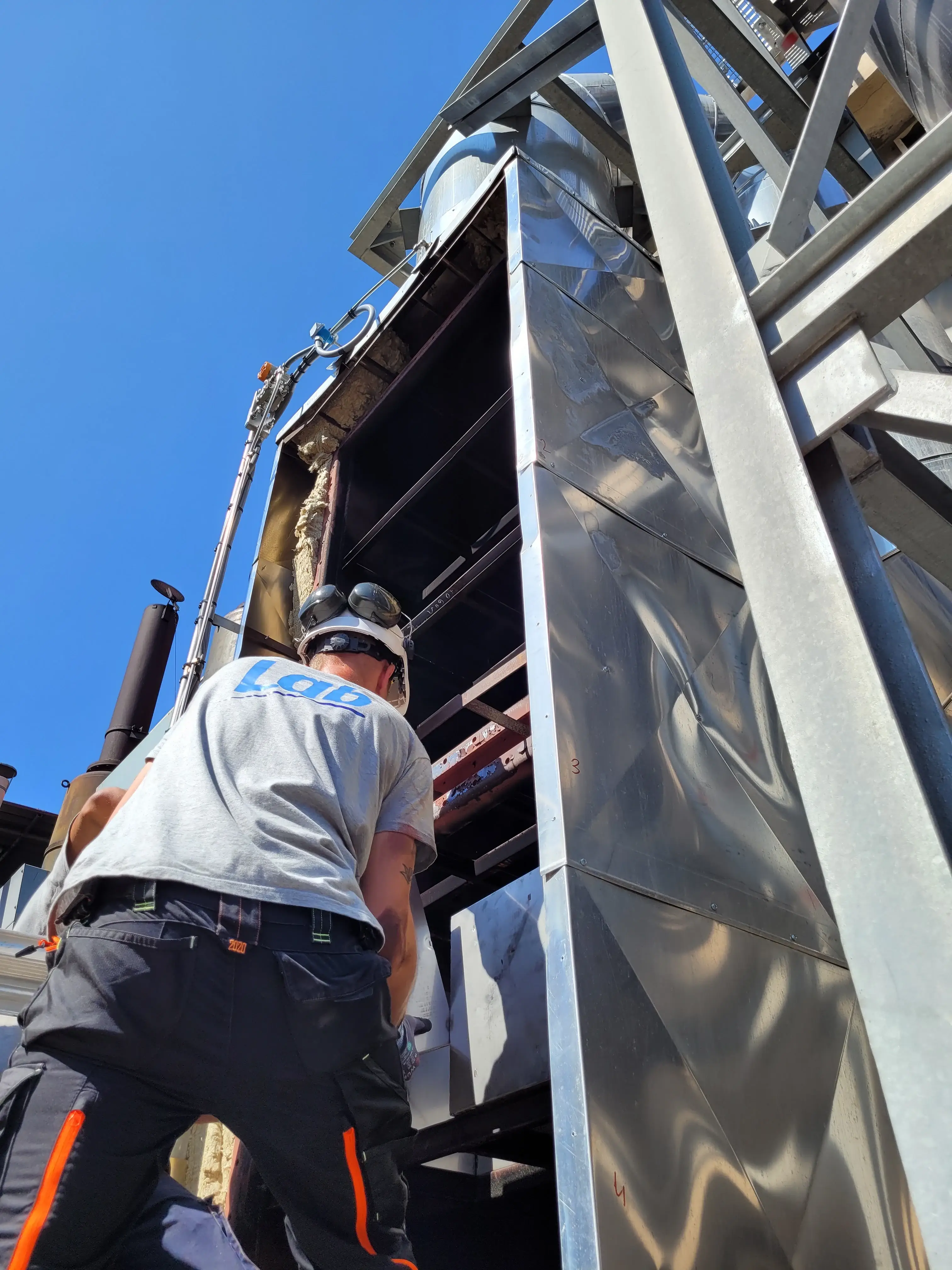 Technicien LAB intervenant sur un équipement industriel de traitement des fumées en installation et maintenance sur site